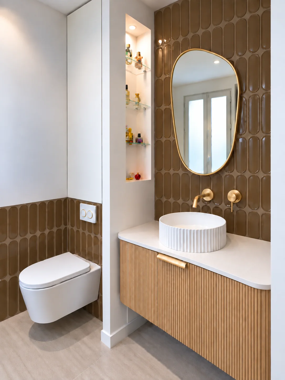 Salle de bains du projet Demours, meuble vasque en bois, miroir ovale et faïence brune.