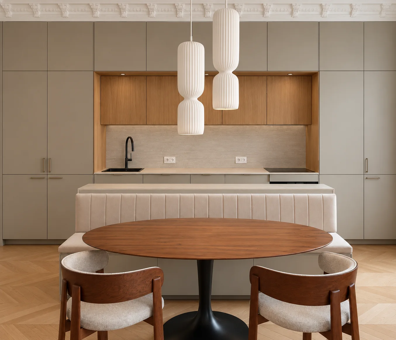 Séjour du projet Demours à Paris, cuisine intégrée, banquette claire, table ovale en bois et deux suspensions sculpturales.