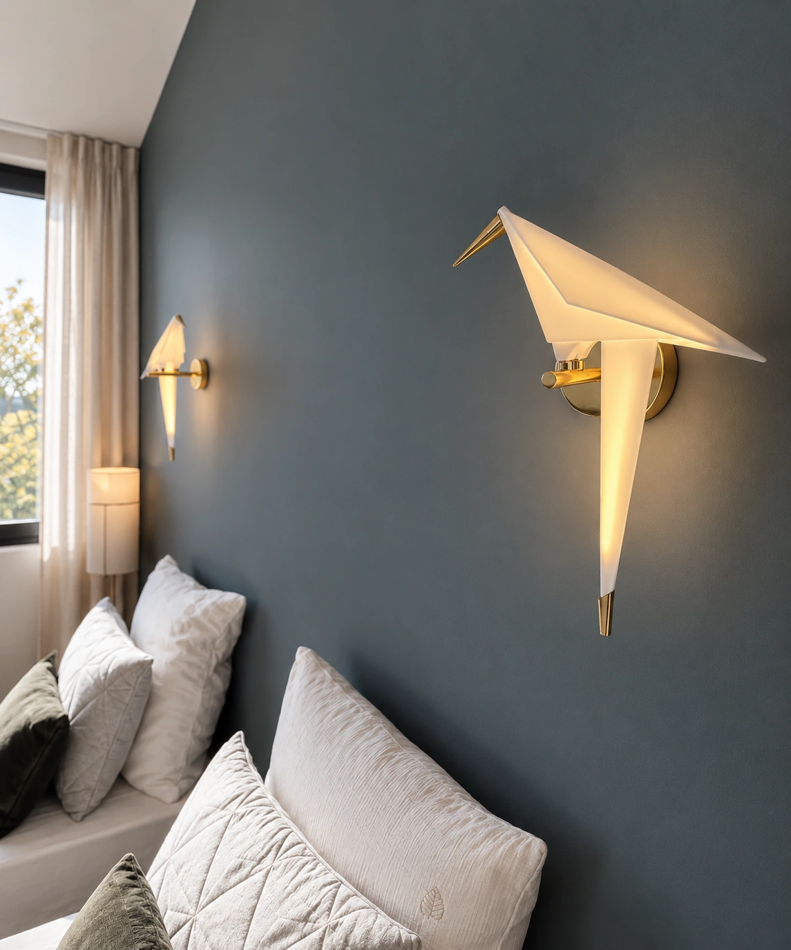 Détail des appliques en forme d’oiseaux sur le mur bleu de la chambre à Dinard.
